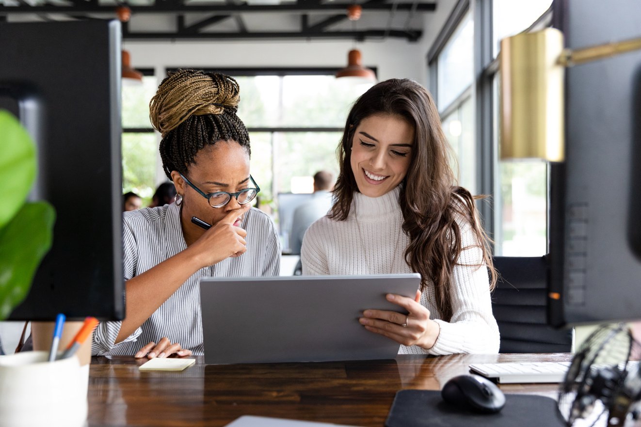 Diverse women use co working space to design newsletter layouts